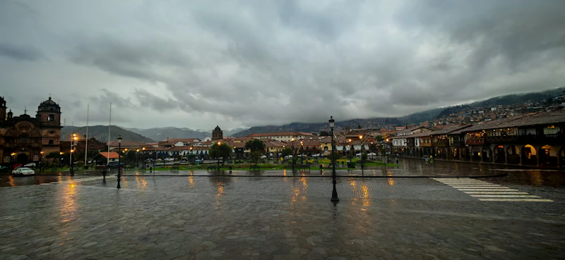 Rain falling on Cusco's Plaza de Armas under an overcast sky