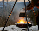 Someone is cooking over a campfire in winter.