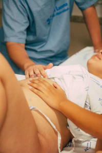 une femme main posées sur son ventre qui va accoucher 