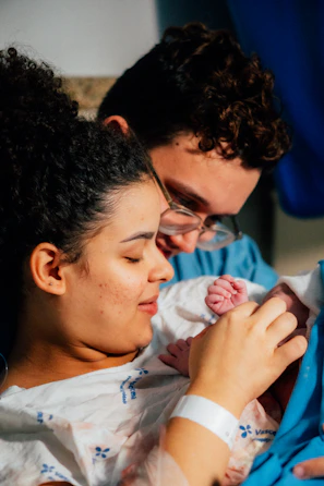 Parents gaze at their newborn baby with love.