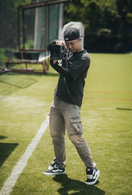 A photographer takes pictures on a green field.