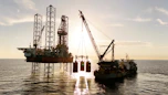 An oil rig being serviced by a supply ship.