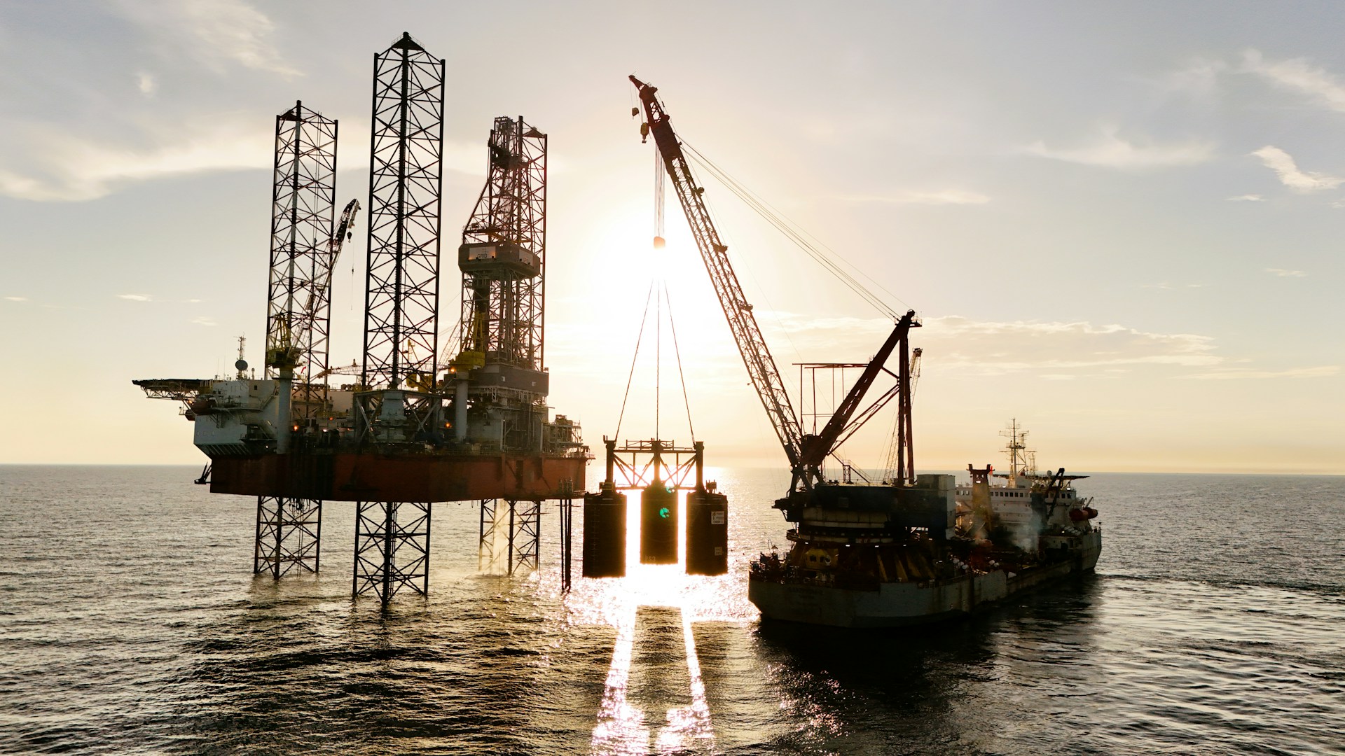 An oil rig being serviced by a supply ship.