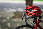 A red bicycle helmet rests on handlebars.