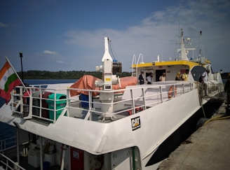 A white boat docks at a pier.