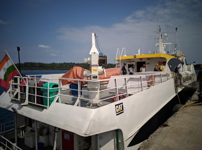 A white boat docks at a pier.