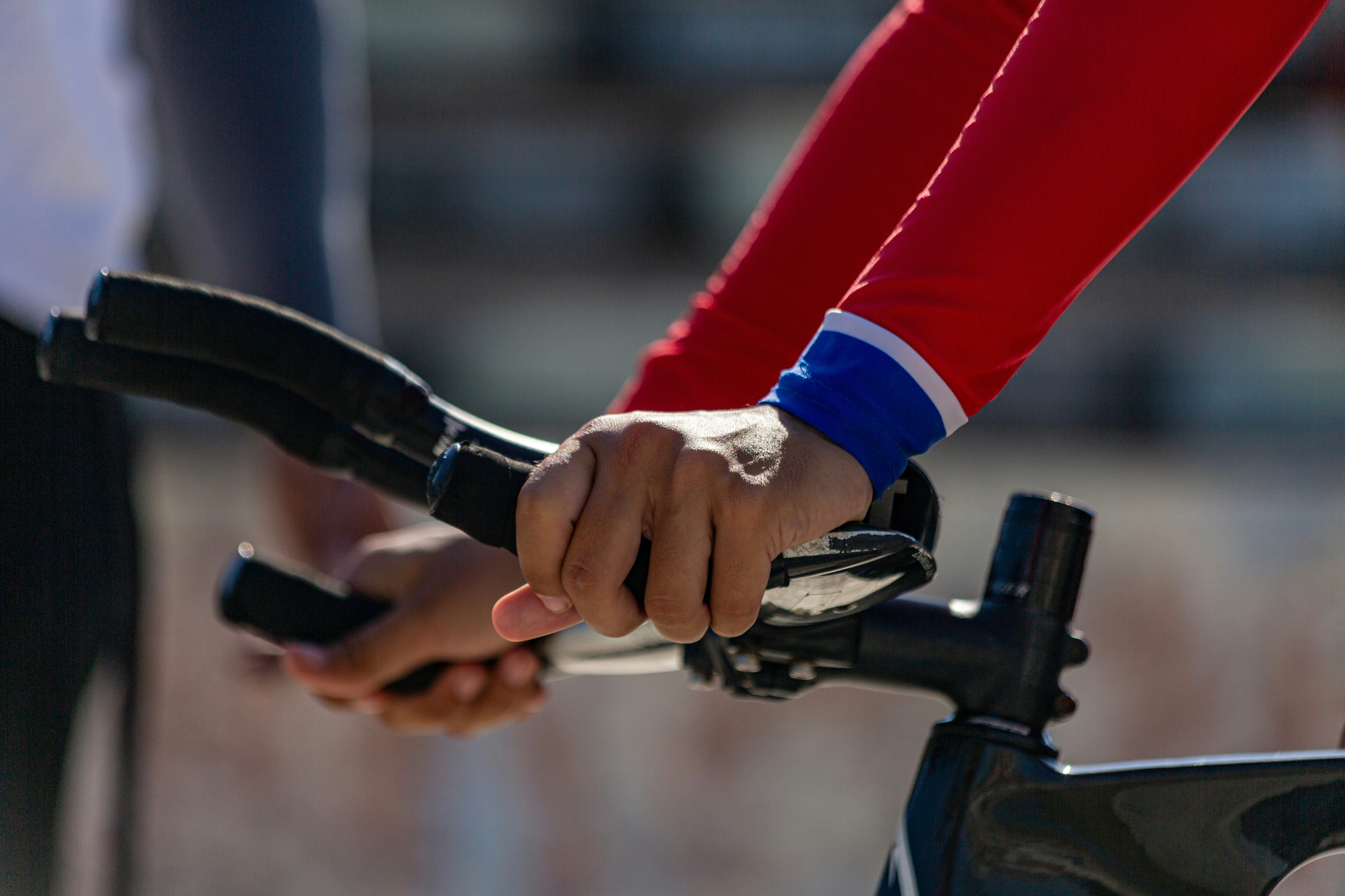 A cyclist grips the handlebars of their bike.