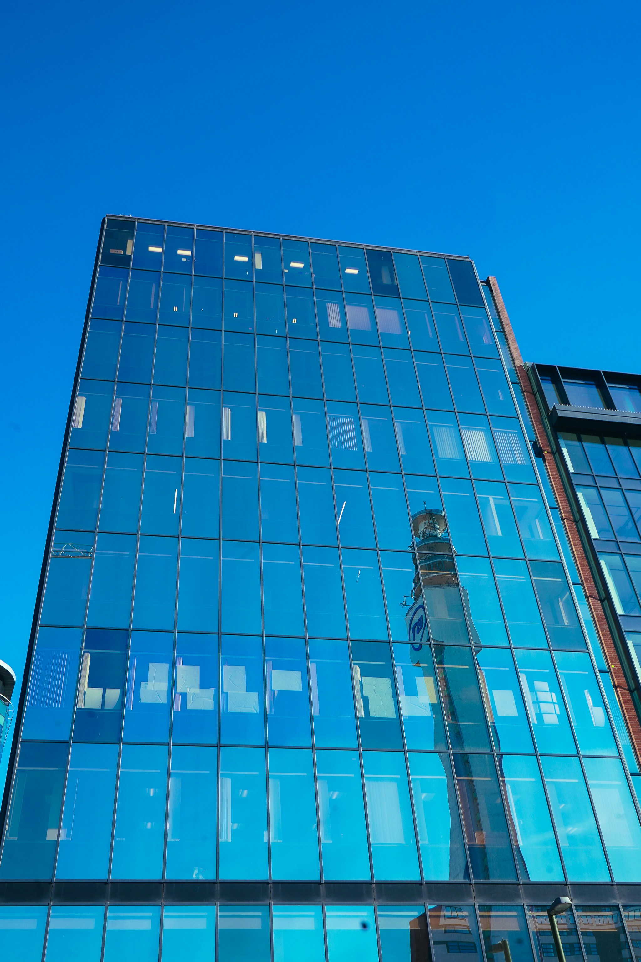 A tall, modern building with a mirrored facade.