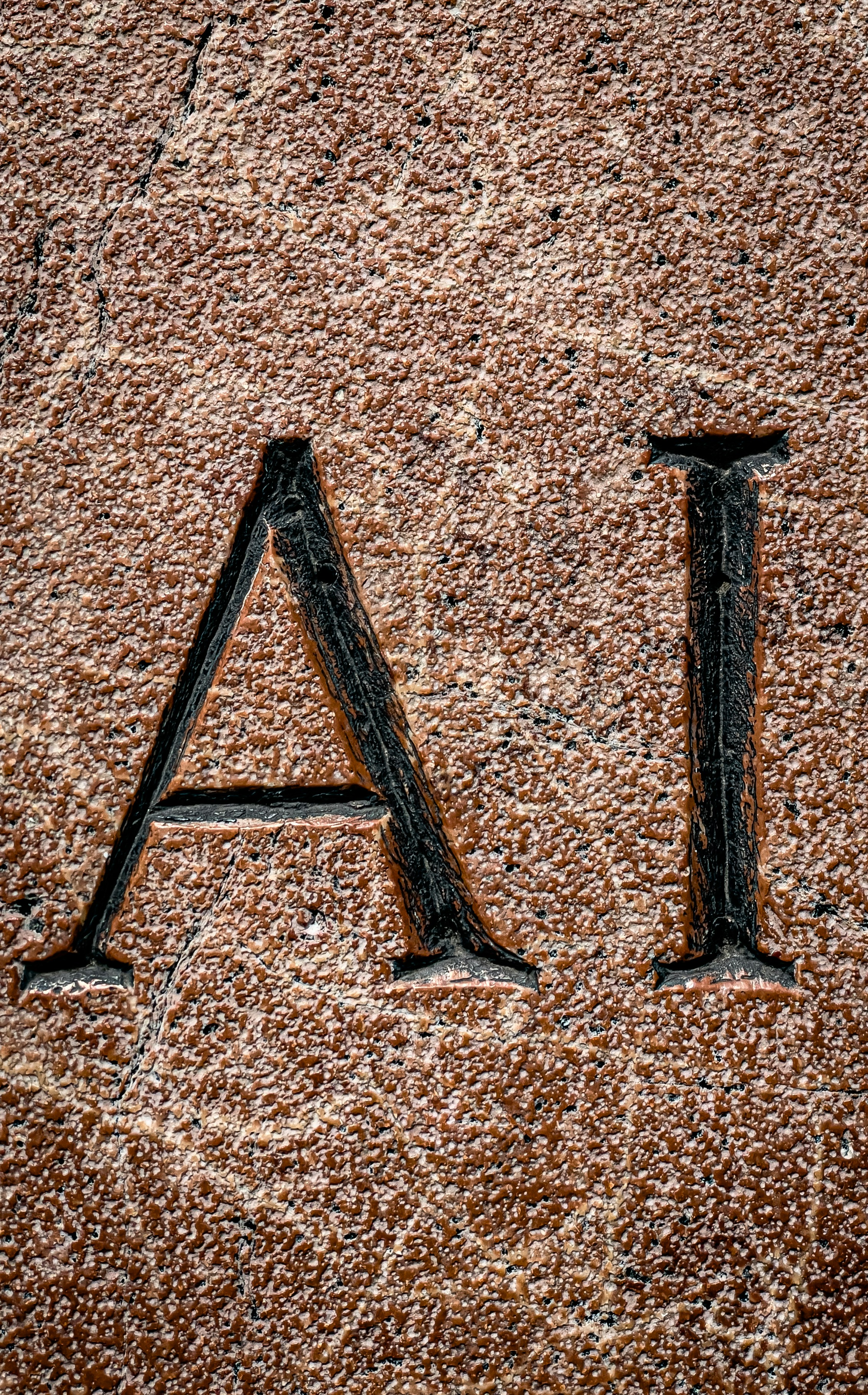 The letters "ai" are carved into a stone.