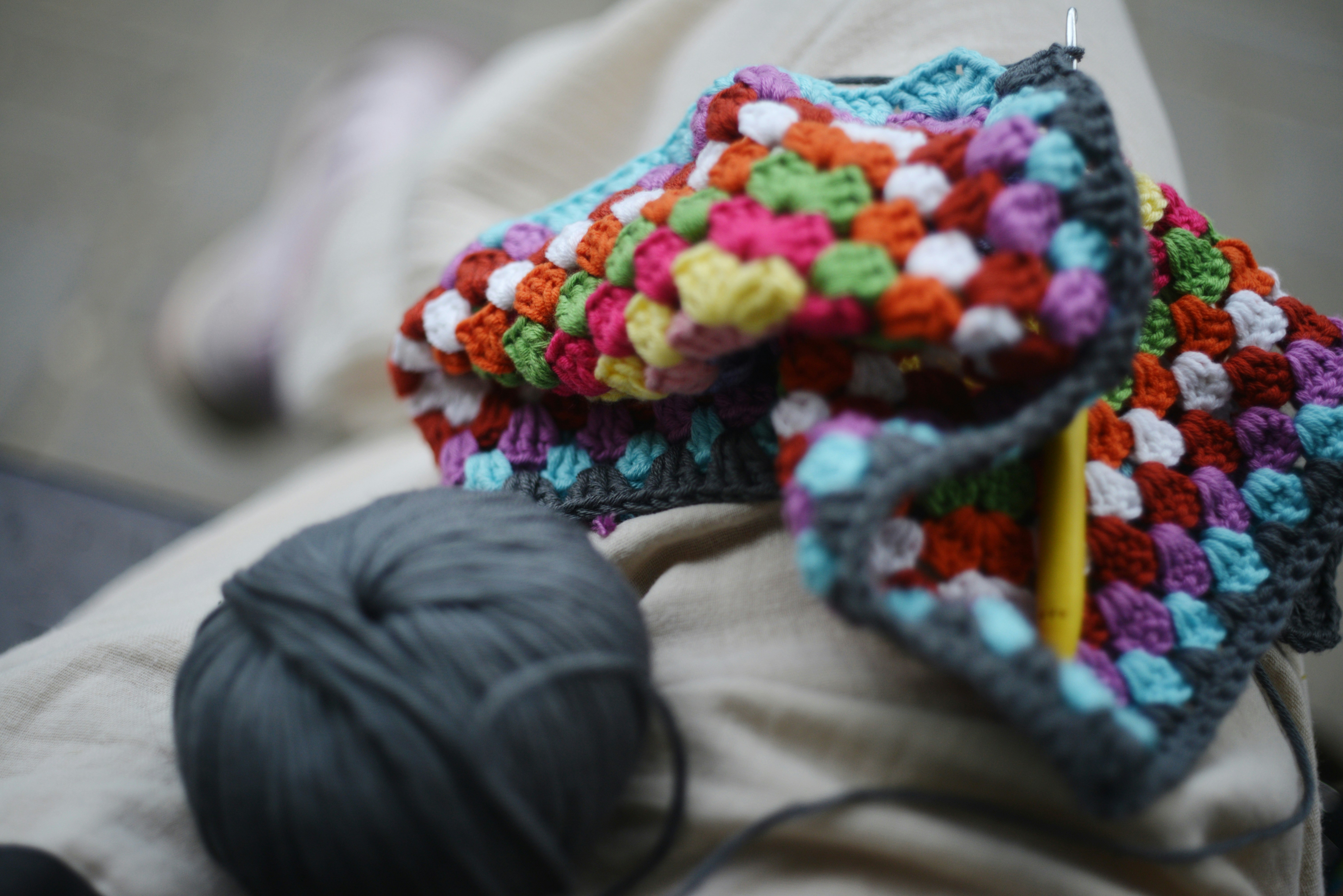 Crocheted blanket in progress with yarn