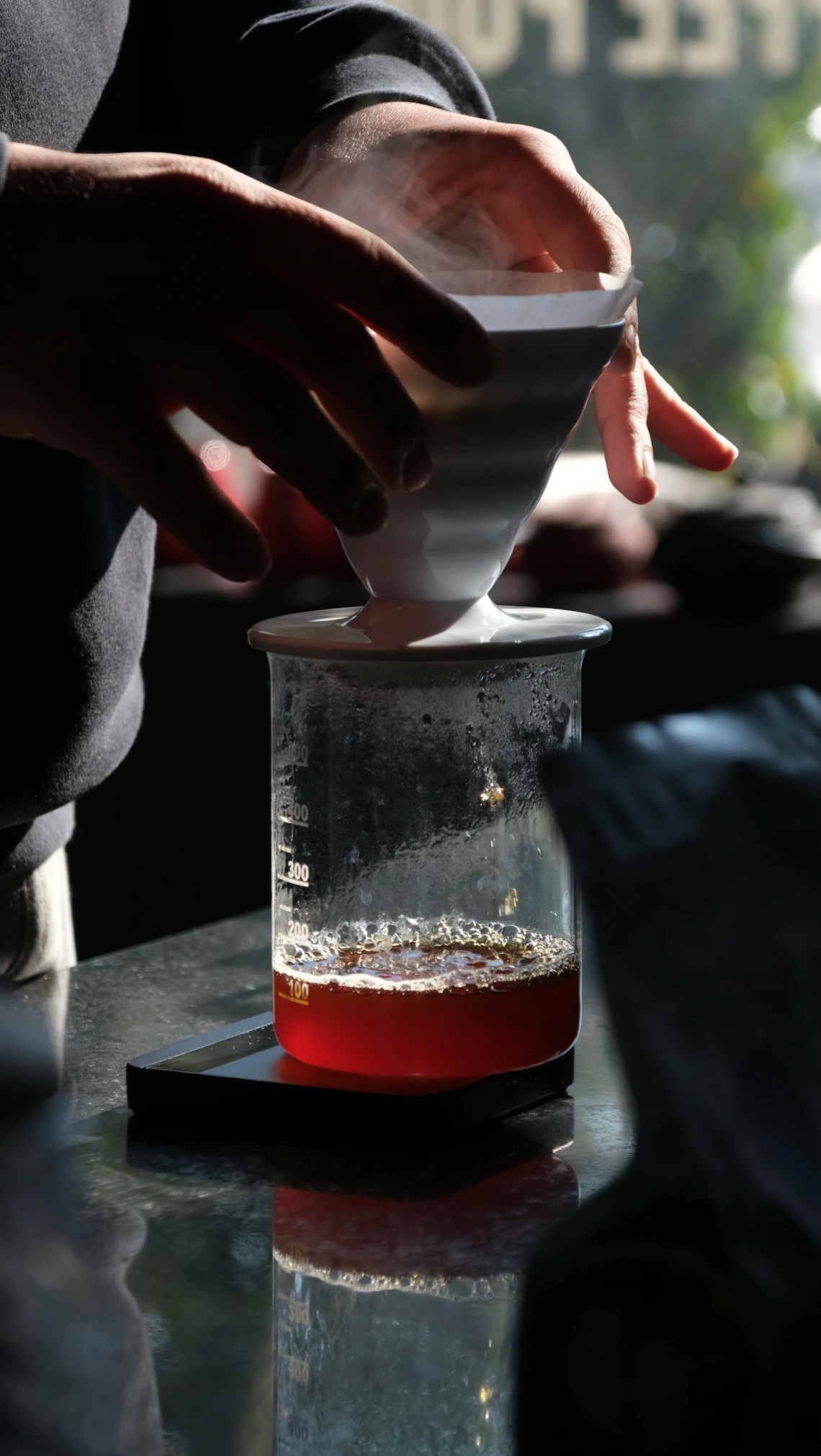 Hands preparing pour-over coffee in warm natural light