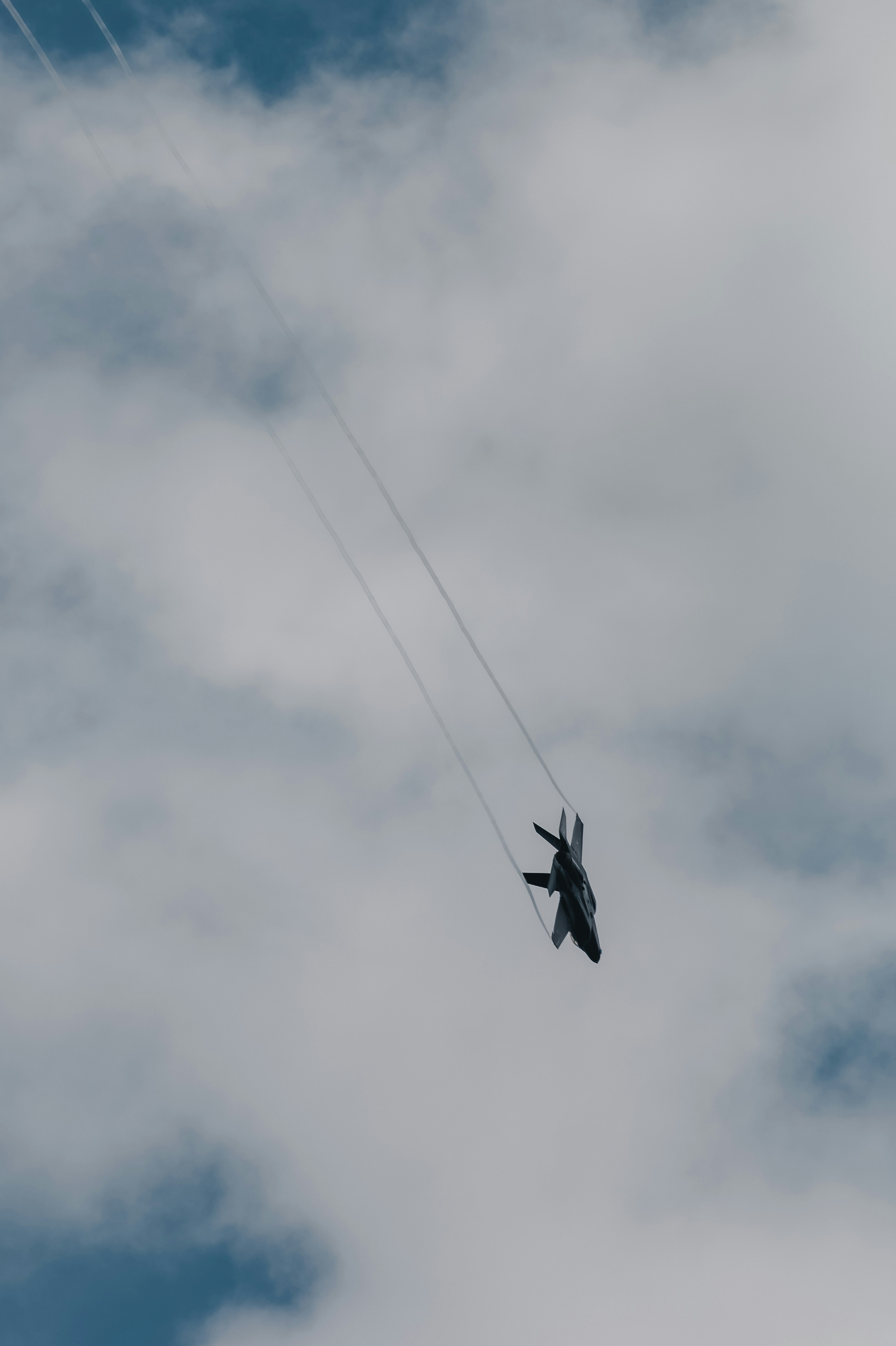 Um jato de combate voa em um céu nublado