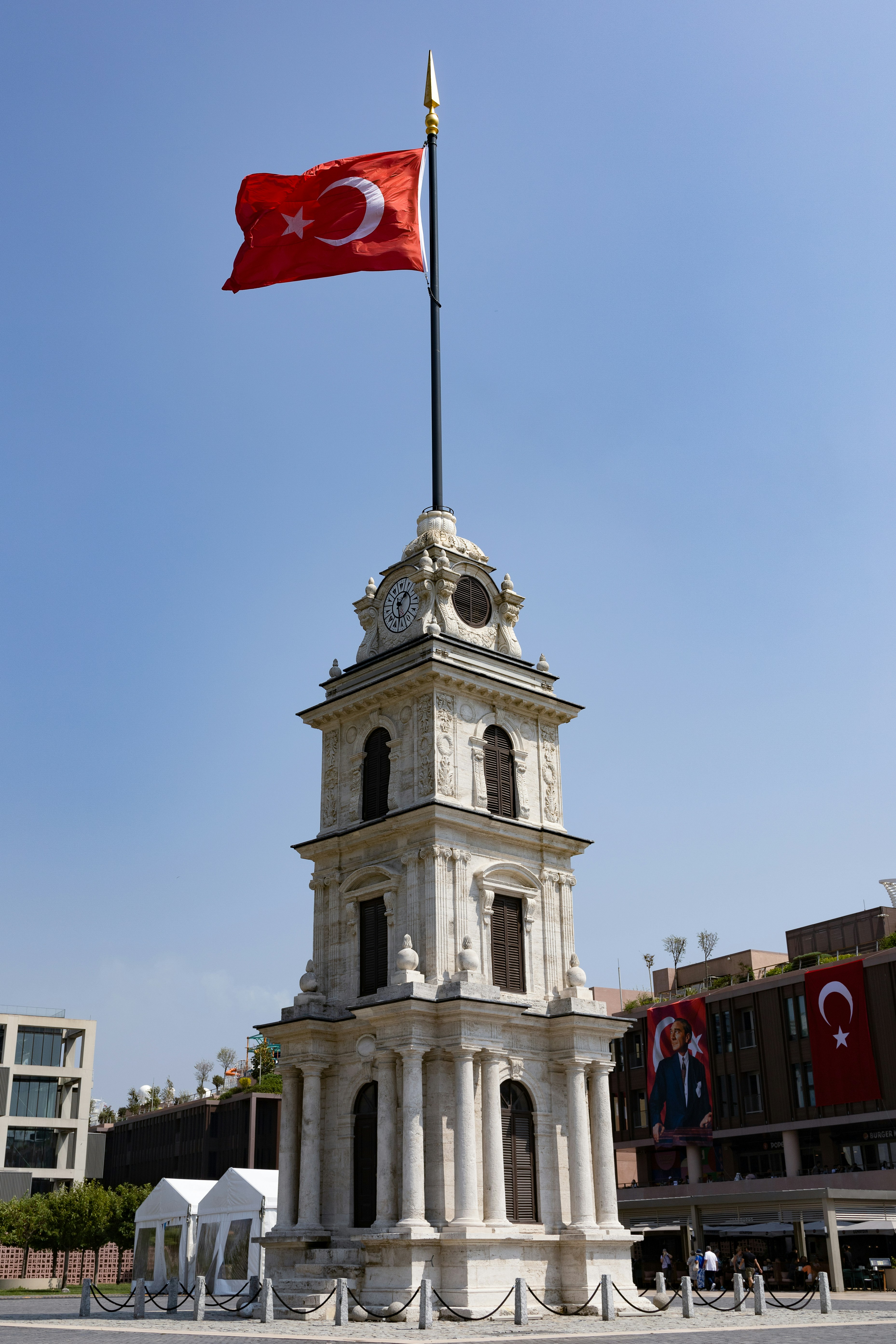 Turkish flag flies above an ornate clock tower.