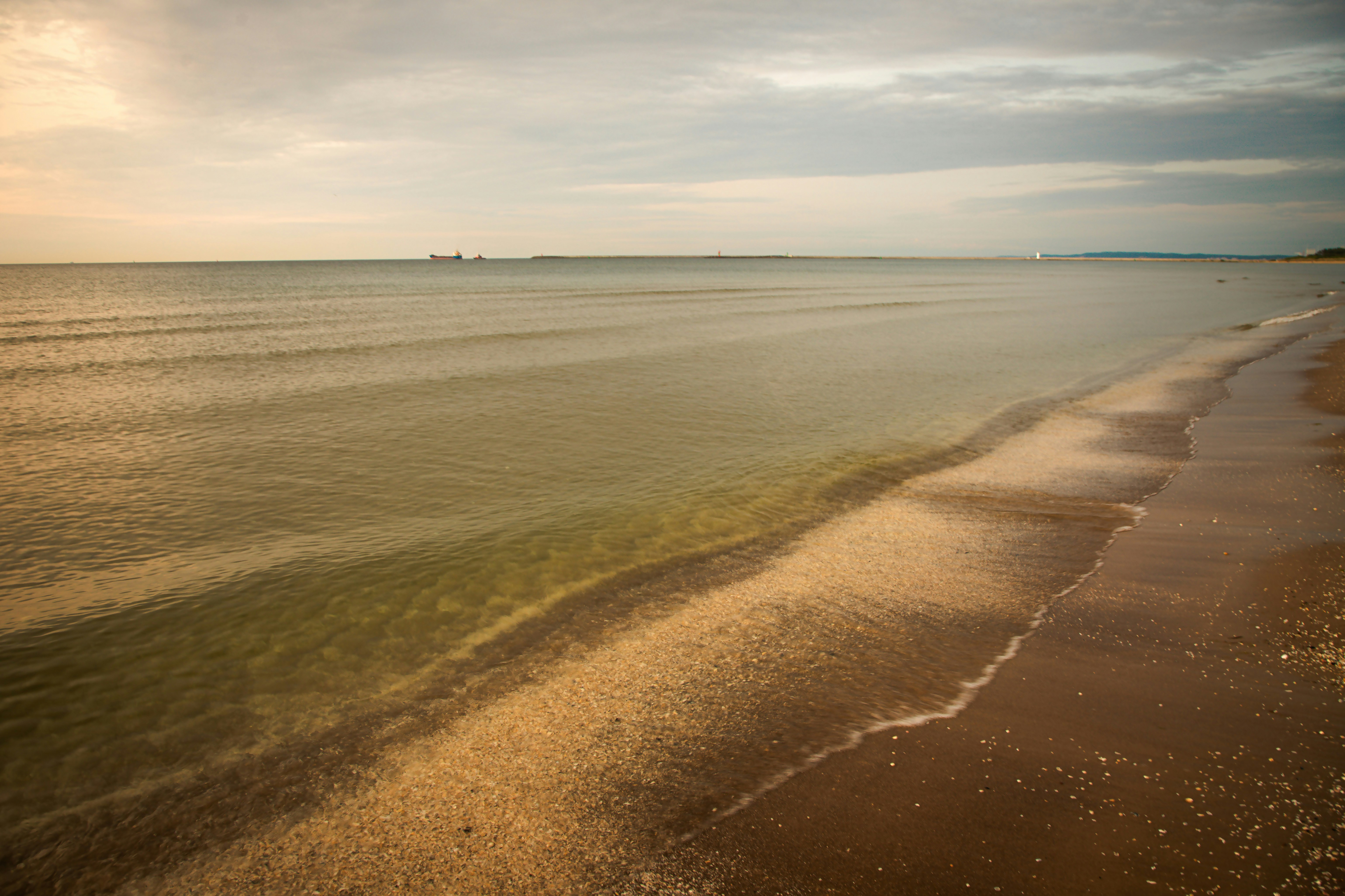 The calm sea meets the sandy beach.