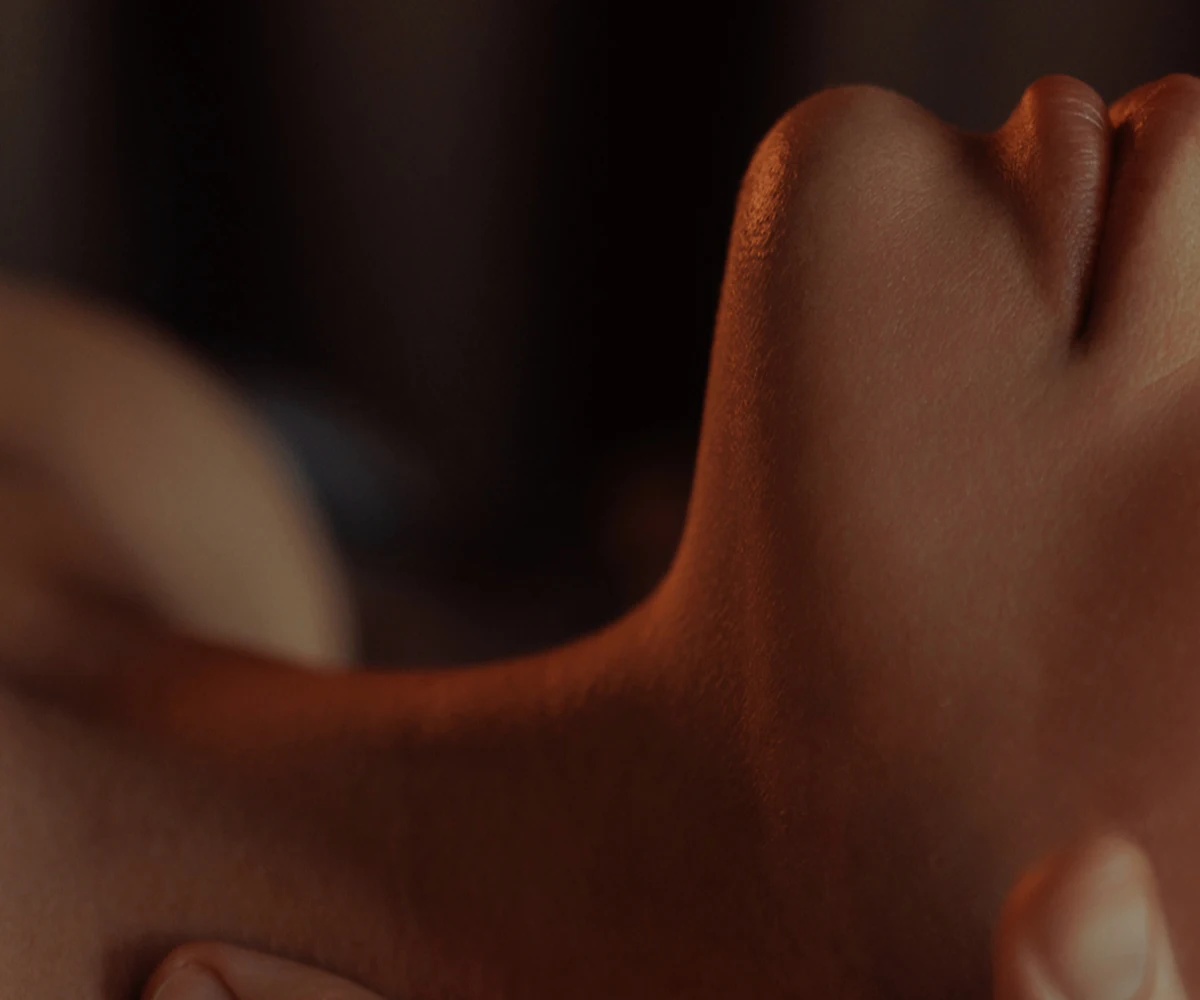 Soft light falling across a relaxed neck and shoulder