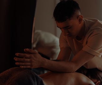 A masseuse is giving someone a back massage.