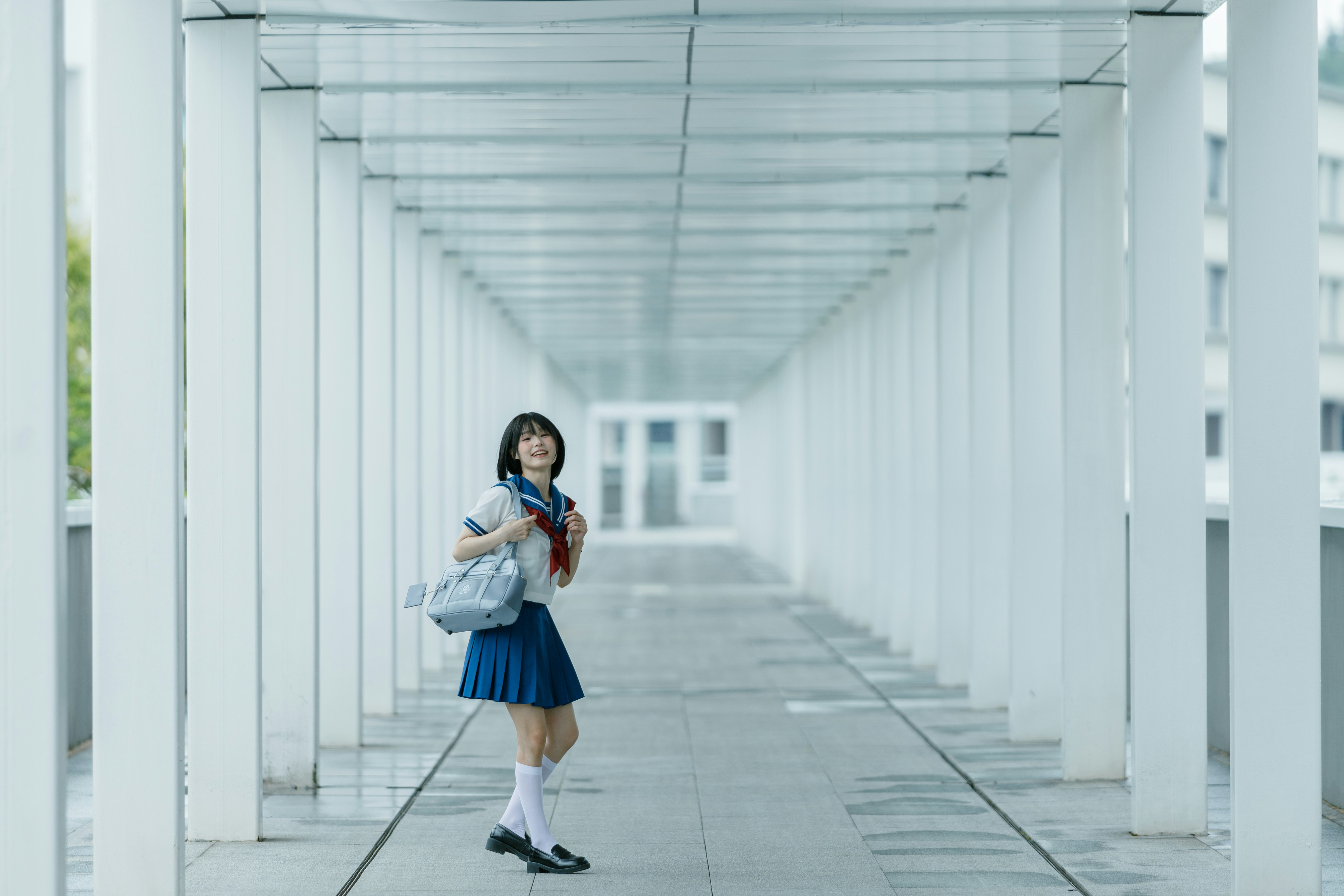 Schoolgirl poses in a white hallway