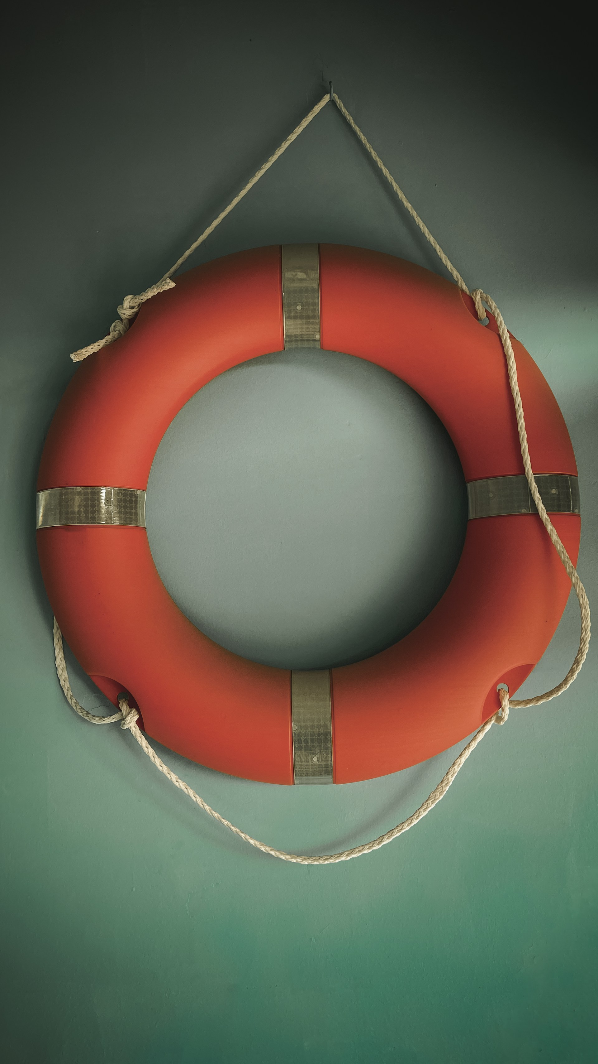 A red life preserver hangs on a wall.