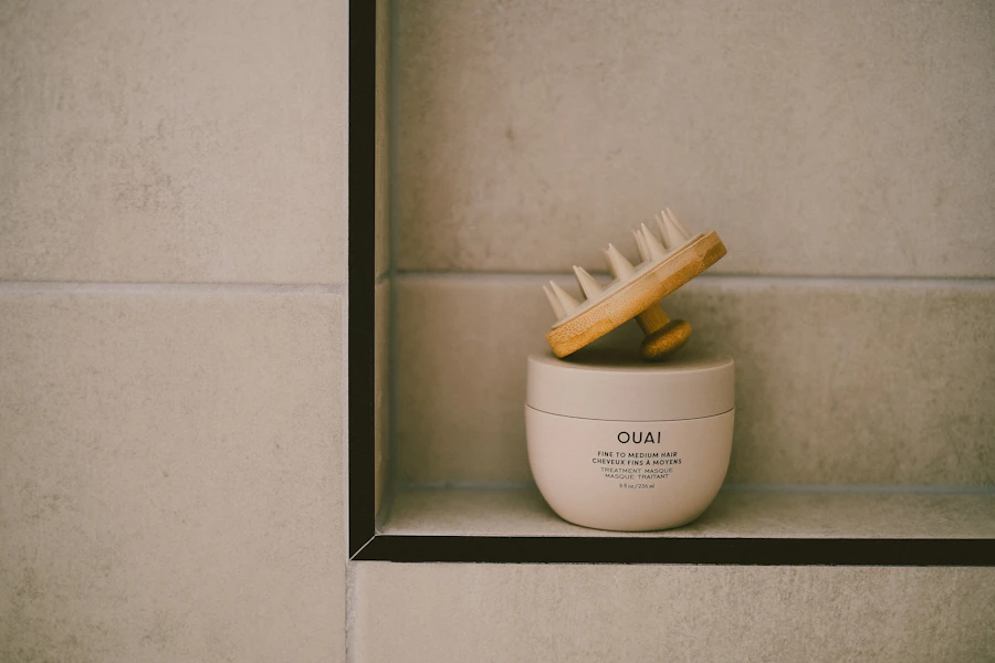A skincare product and brush are on a shelf.
