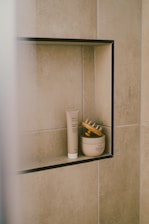 Bathroom products sit inside a tiled niche.