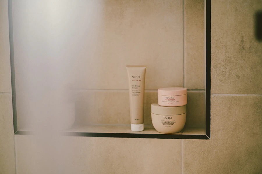 Skincare products sit on a shelf in a shower.