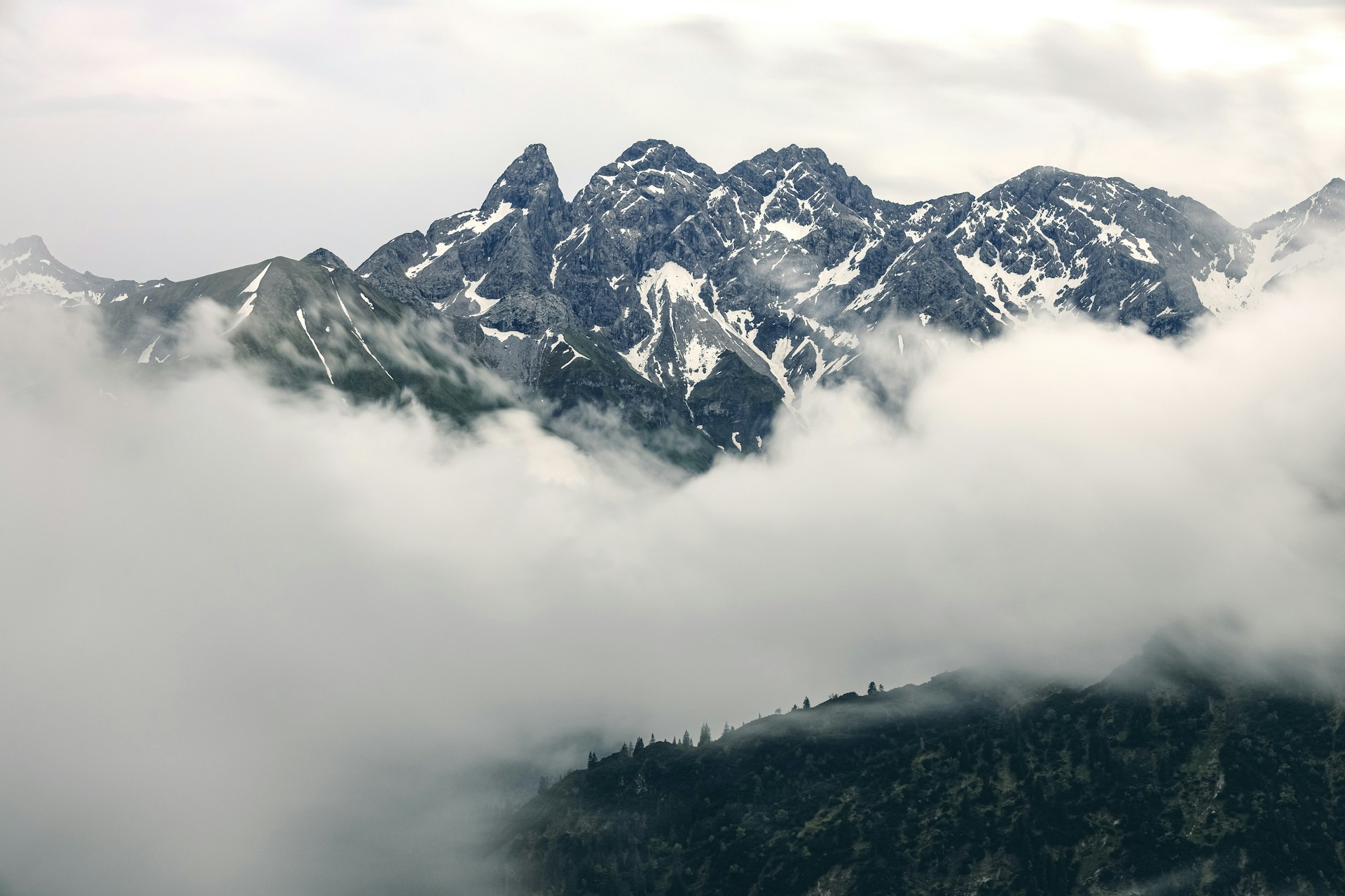 Mountains emerge from the clouds on a hazy day.