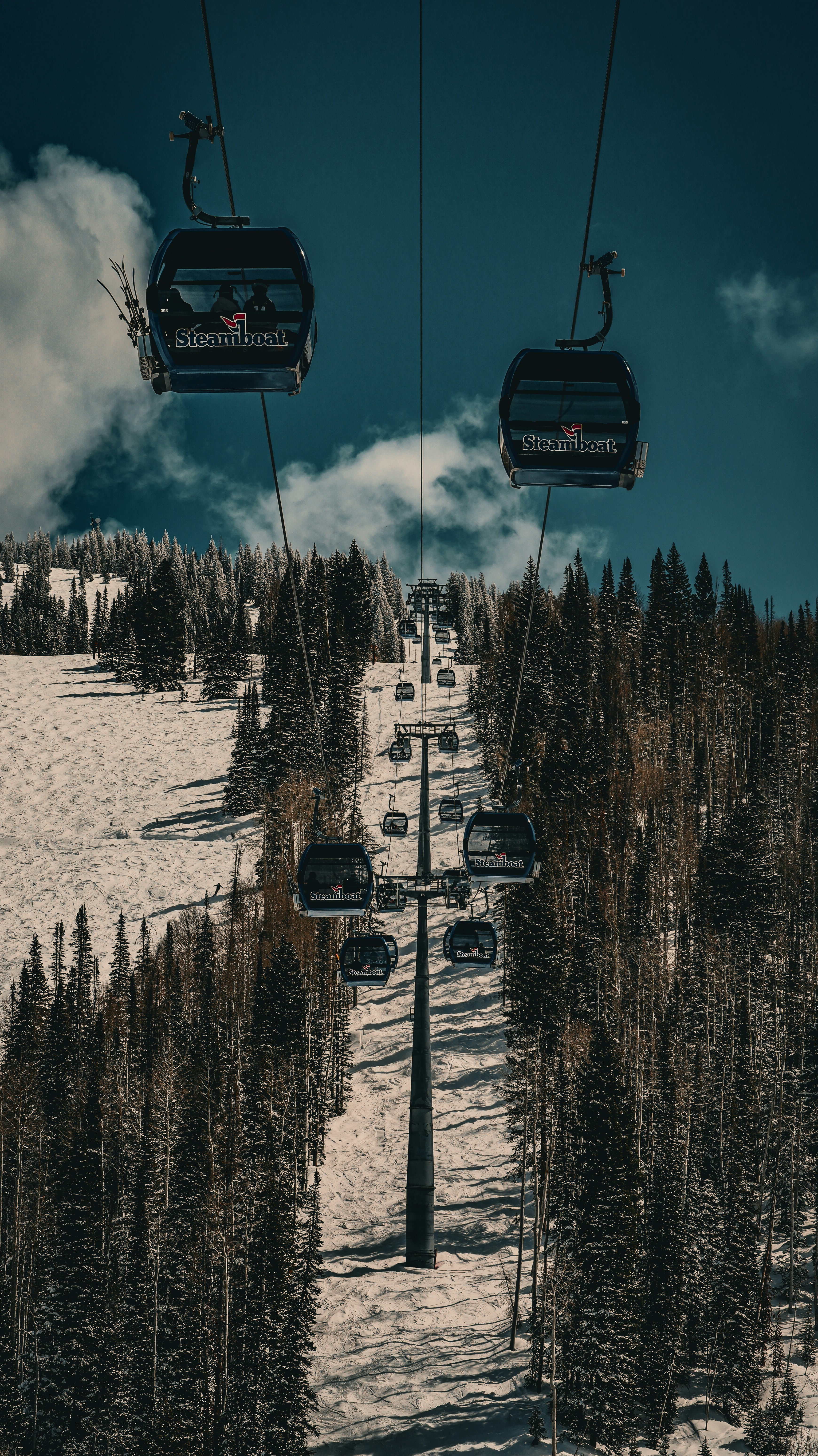 Ski lift ascending up a snowy mountain.