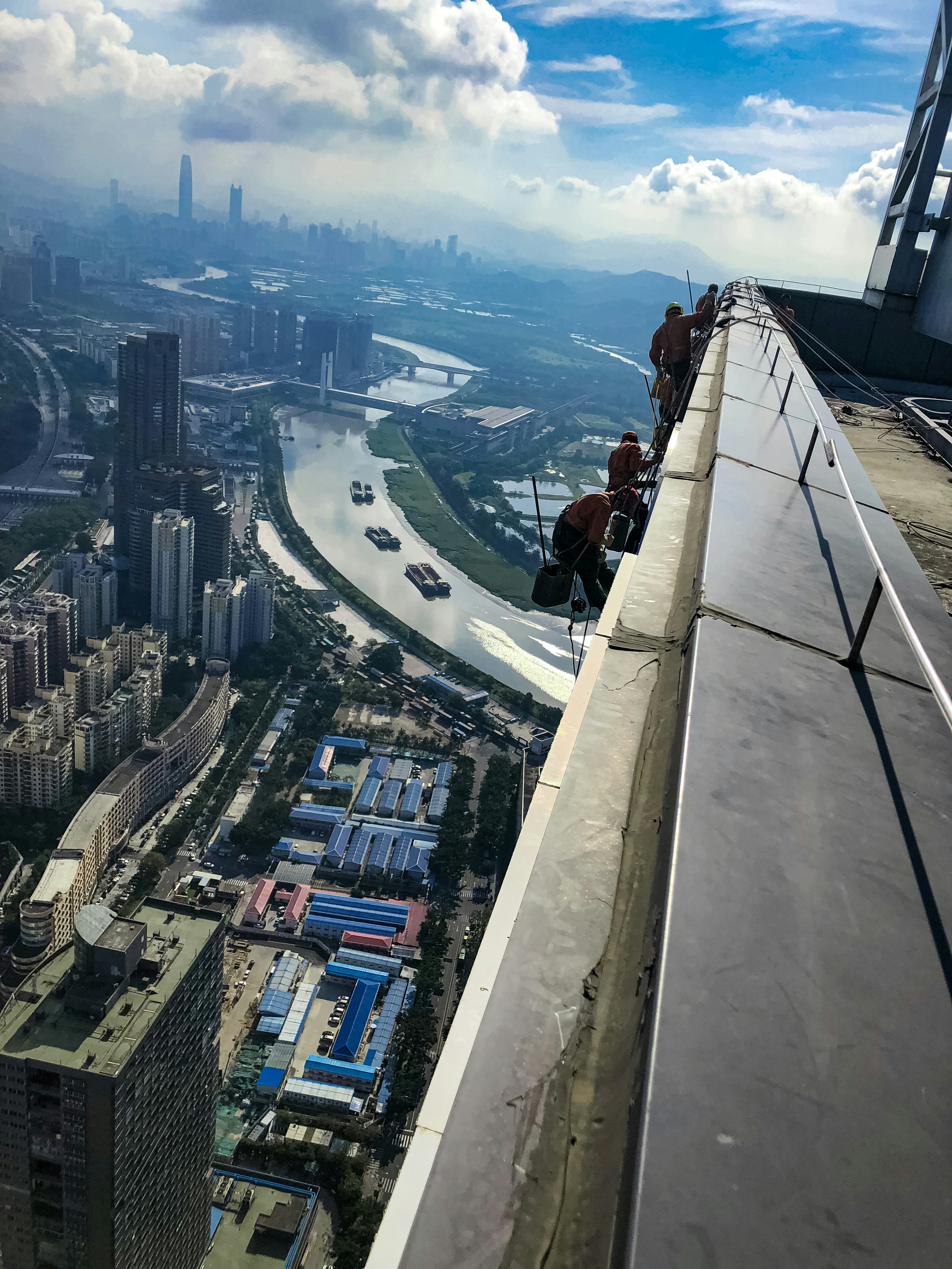 Los trabajadores están en el borde de un edificio muy alto.