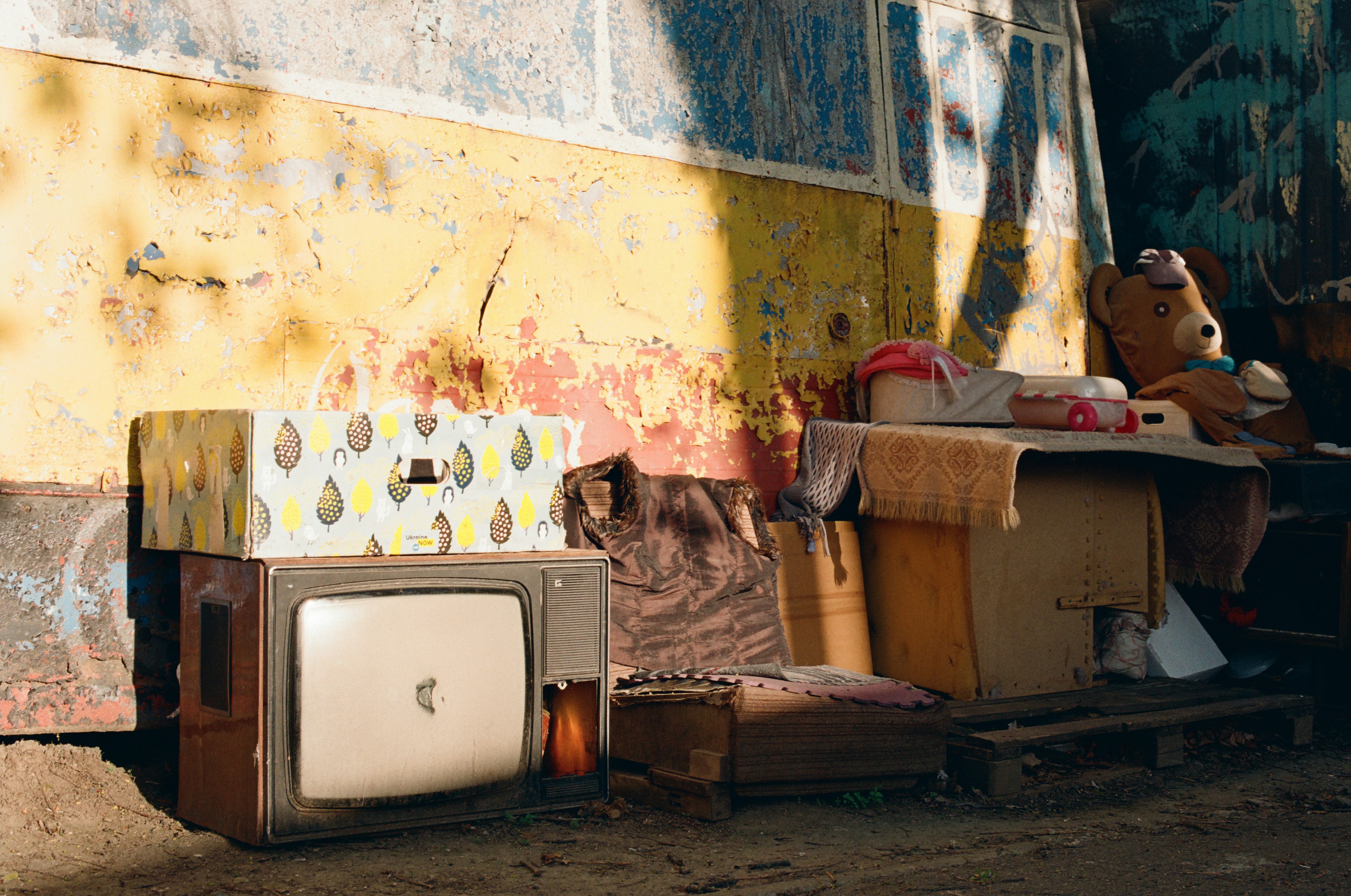 Old furniture and objects stand outdoors.