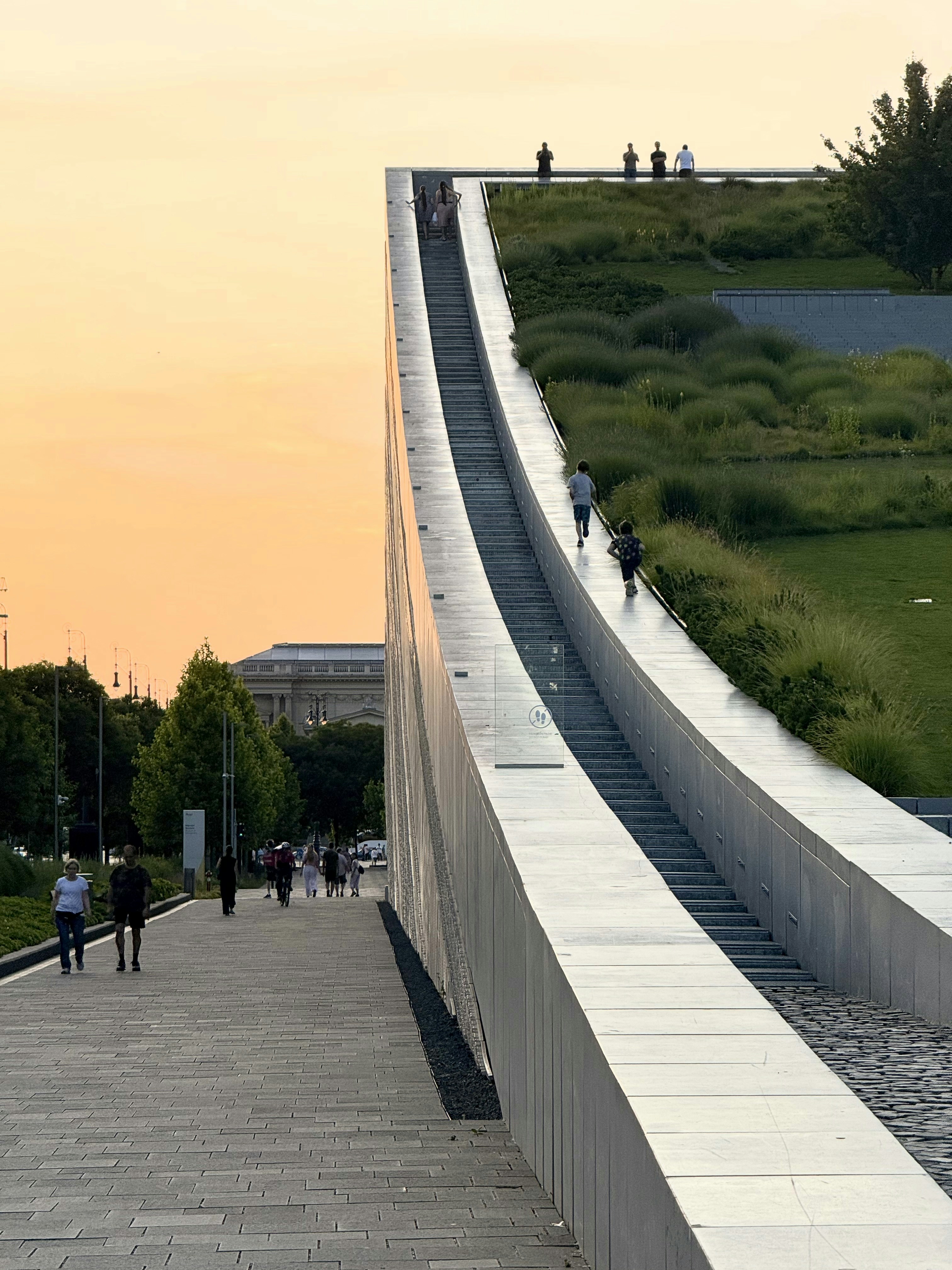 As pessoas caminham e correm por uma estrutura arquitetônica moderna.