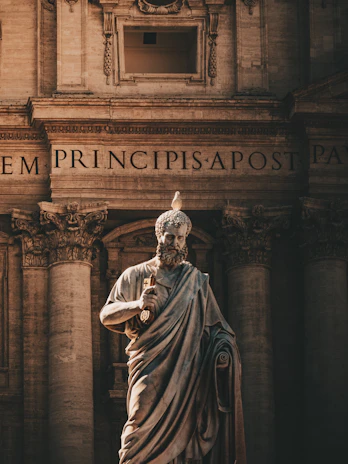 A statue of saint peter with a bird.