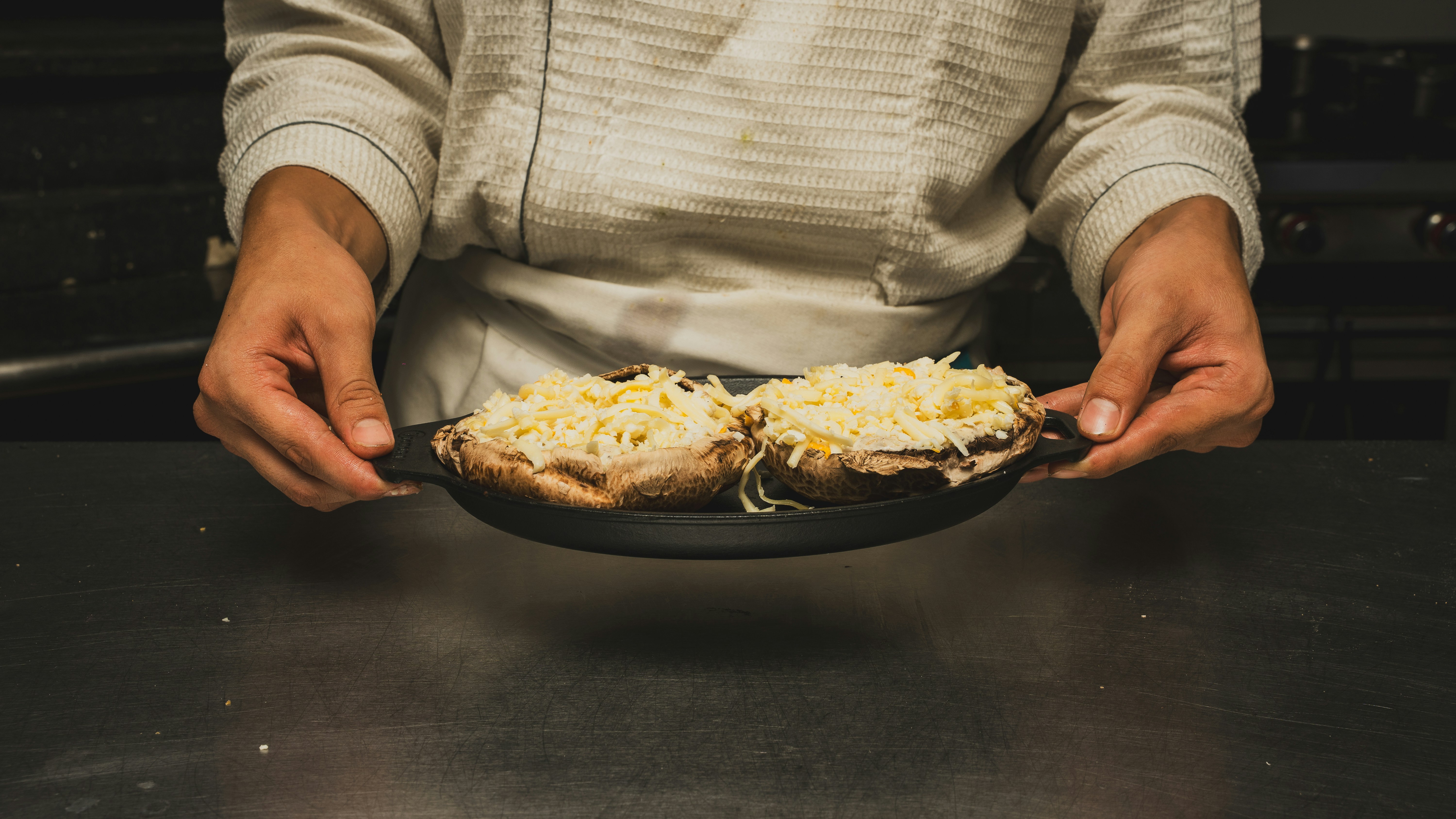 Un chef sostiene dos platos de champiñones.
