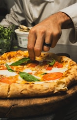 Chef adding basil to a delicious-looking pizza.