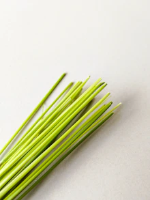 Fresh chives are laid out on a light surface