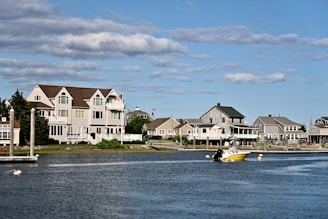 Houses line a harbor with a boat in the water.