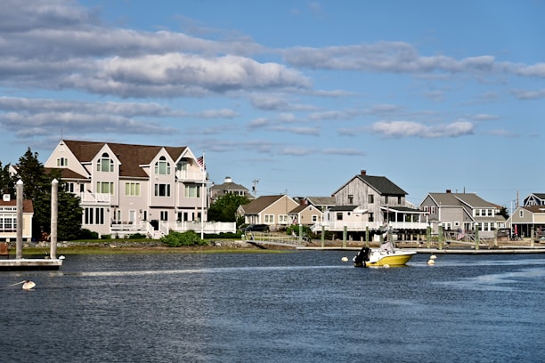 Houses line a harbor with a boat in the water.
