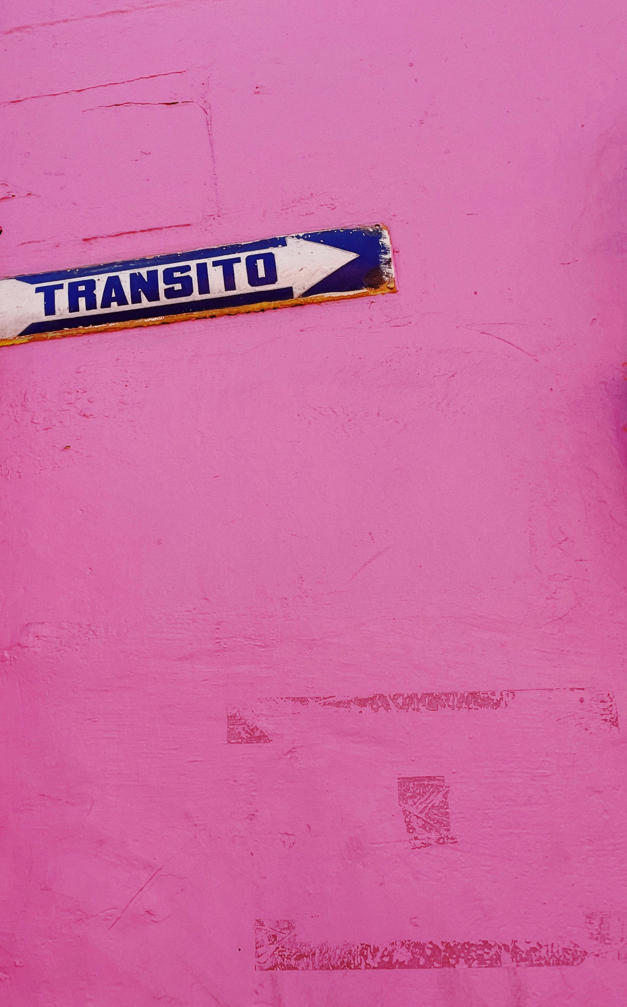 A "transito" sign points right on pink.