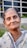 An older woman smiles at the camera.
