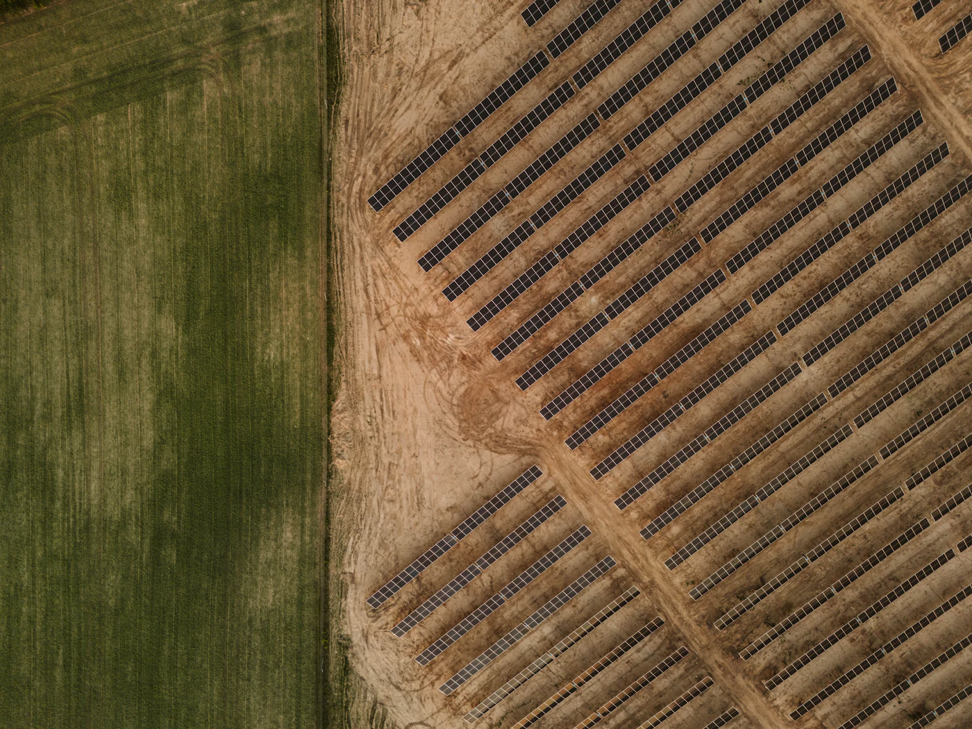 Photovoltaic plant seen from directly above, next to farmland plots