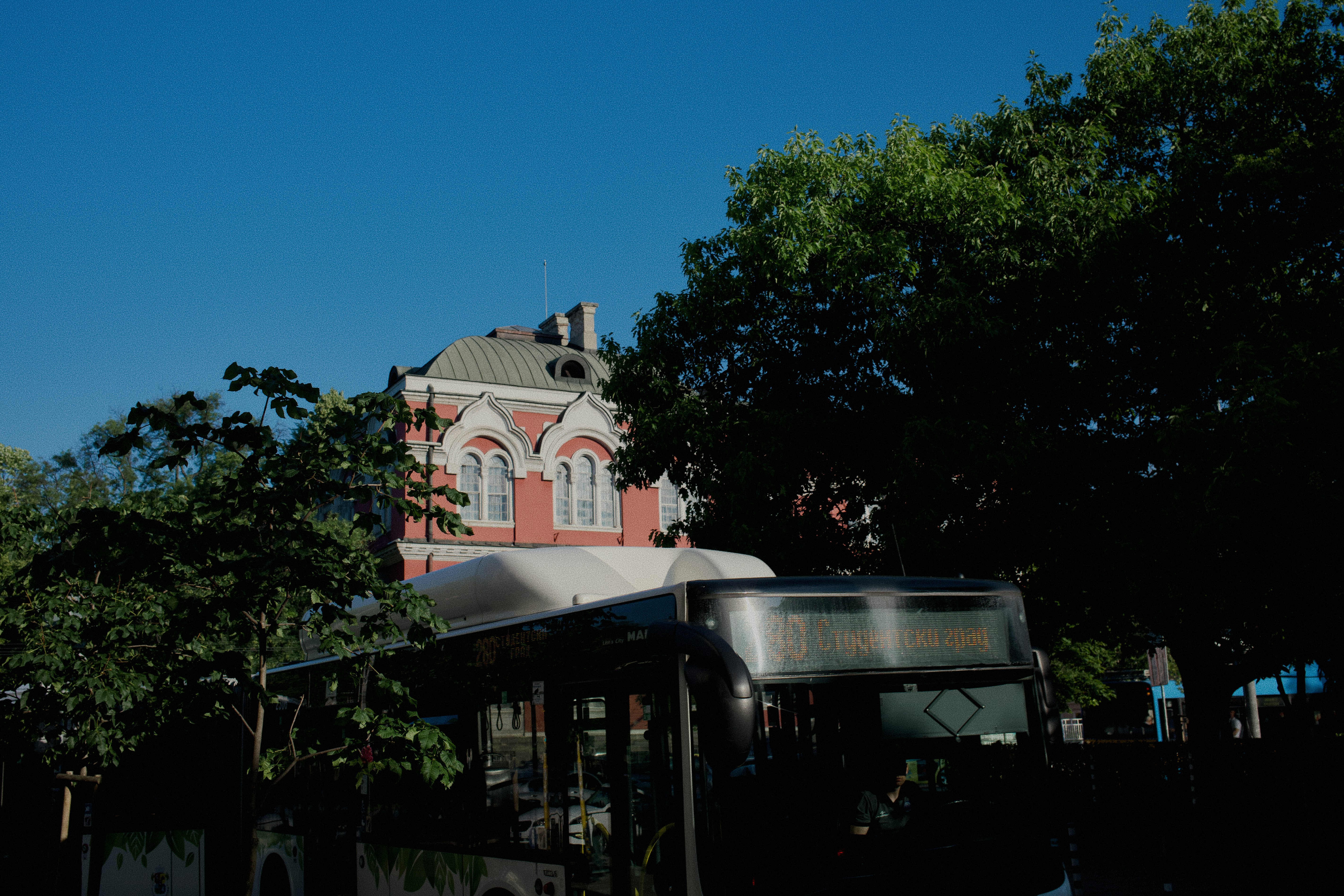 A bus is parked near a beautiful building.