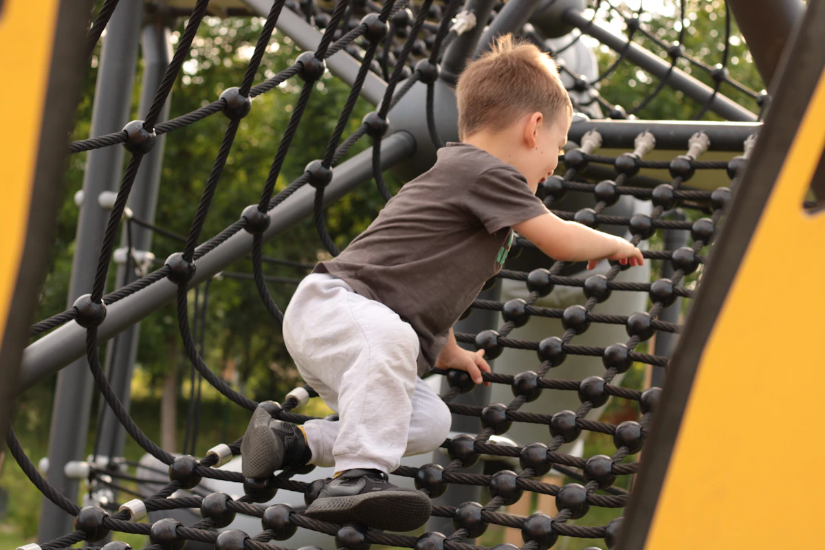 Young child climbing on playground equipment outdoors