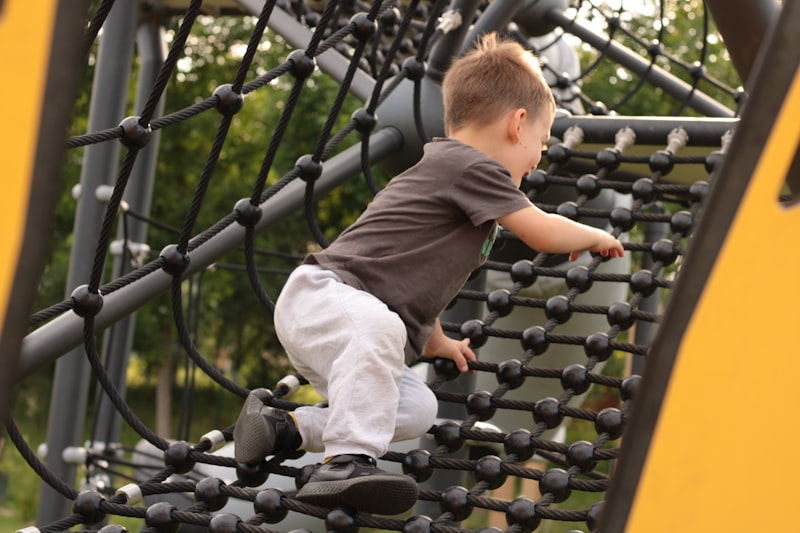 A child climbing a playground net in sneakers at recess