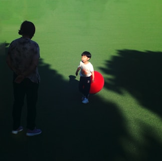 A child plays with a red ball.