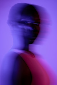 Blurred silhouette of a person in purple light.