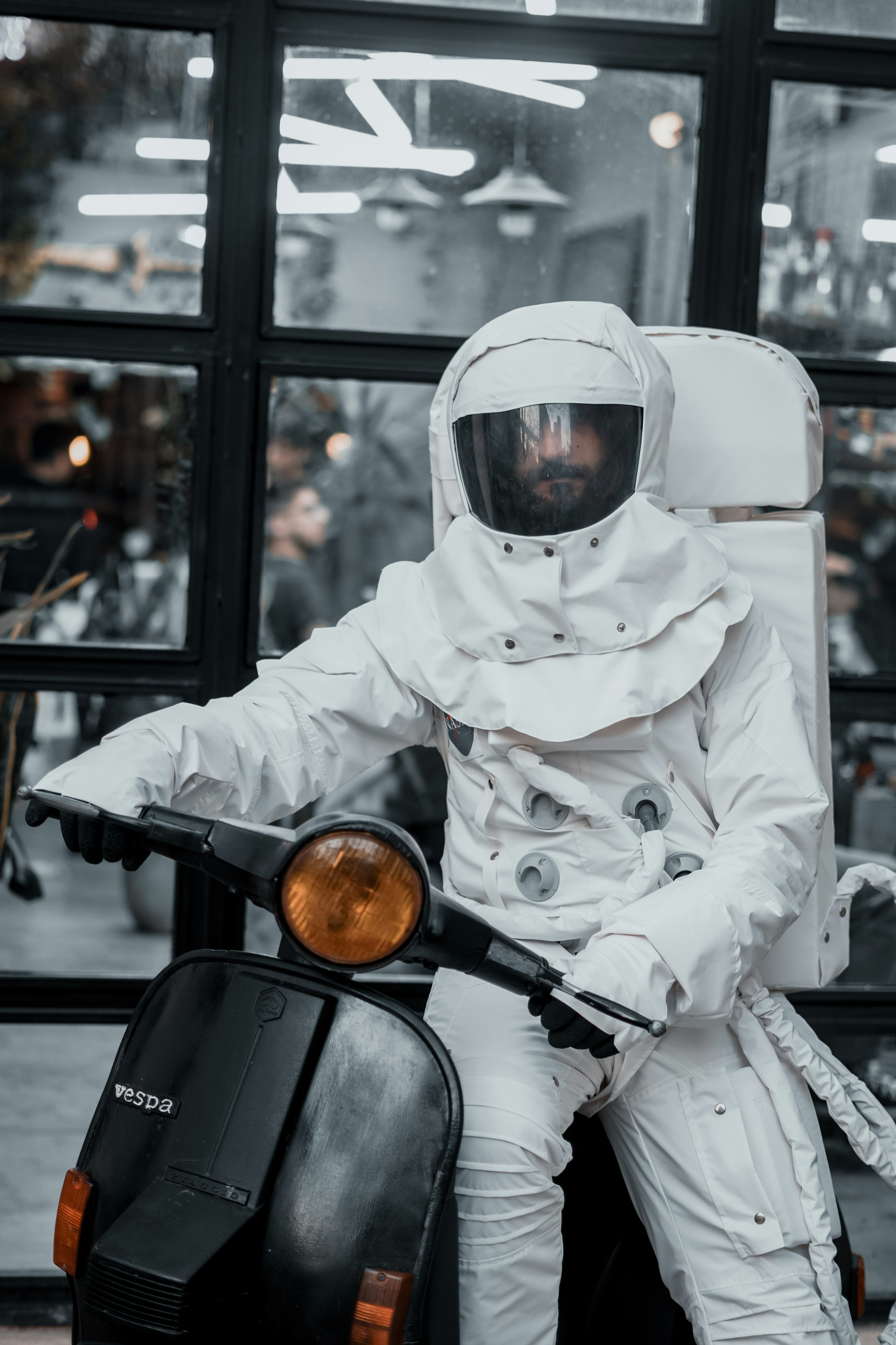 Astronaut on a vespa scooter posing for a photo.