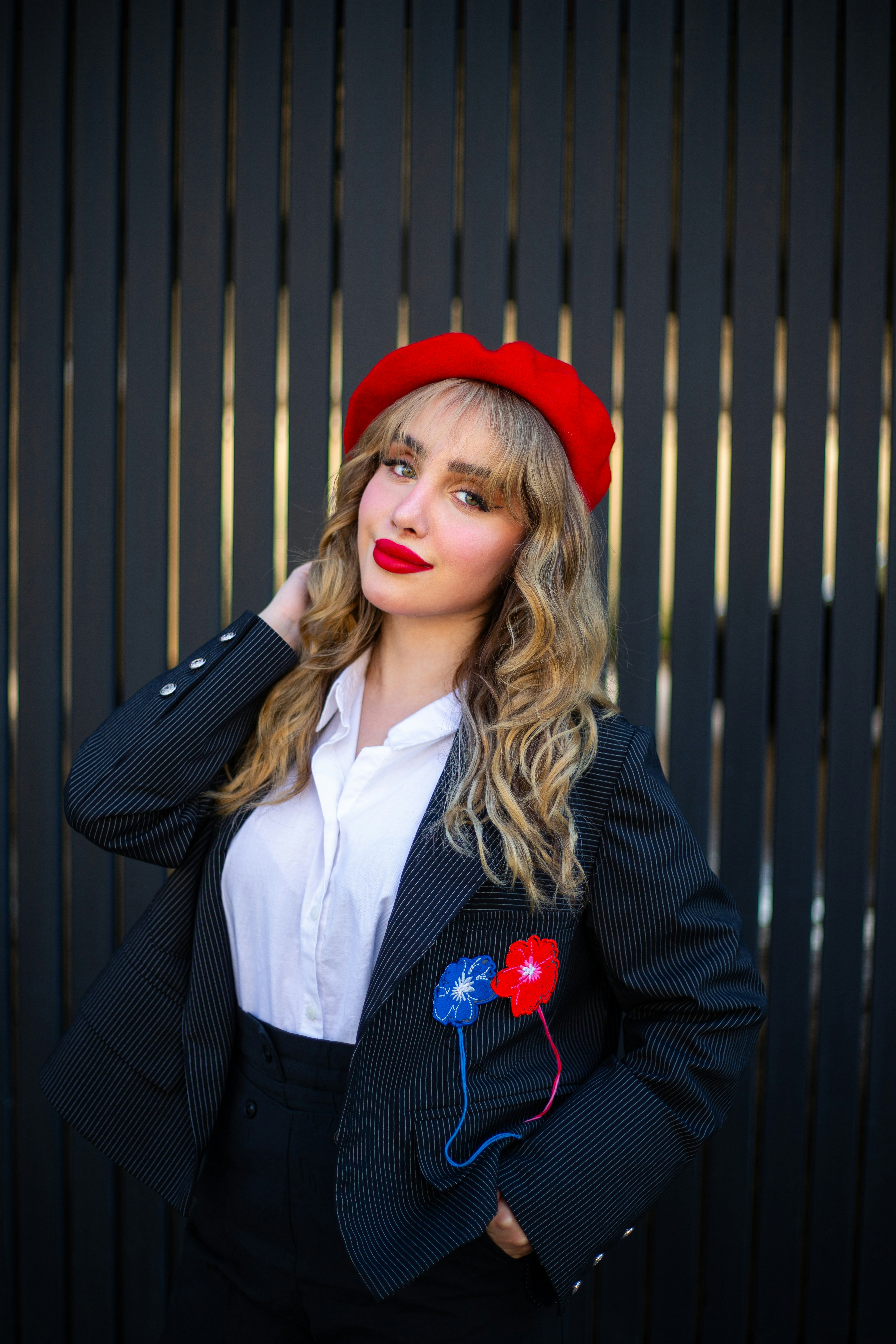 Wanita cantik dengan blazer dan baret merah.