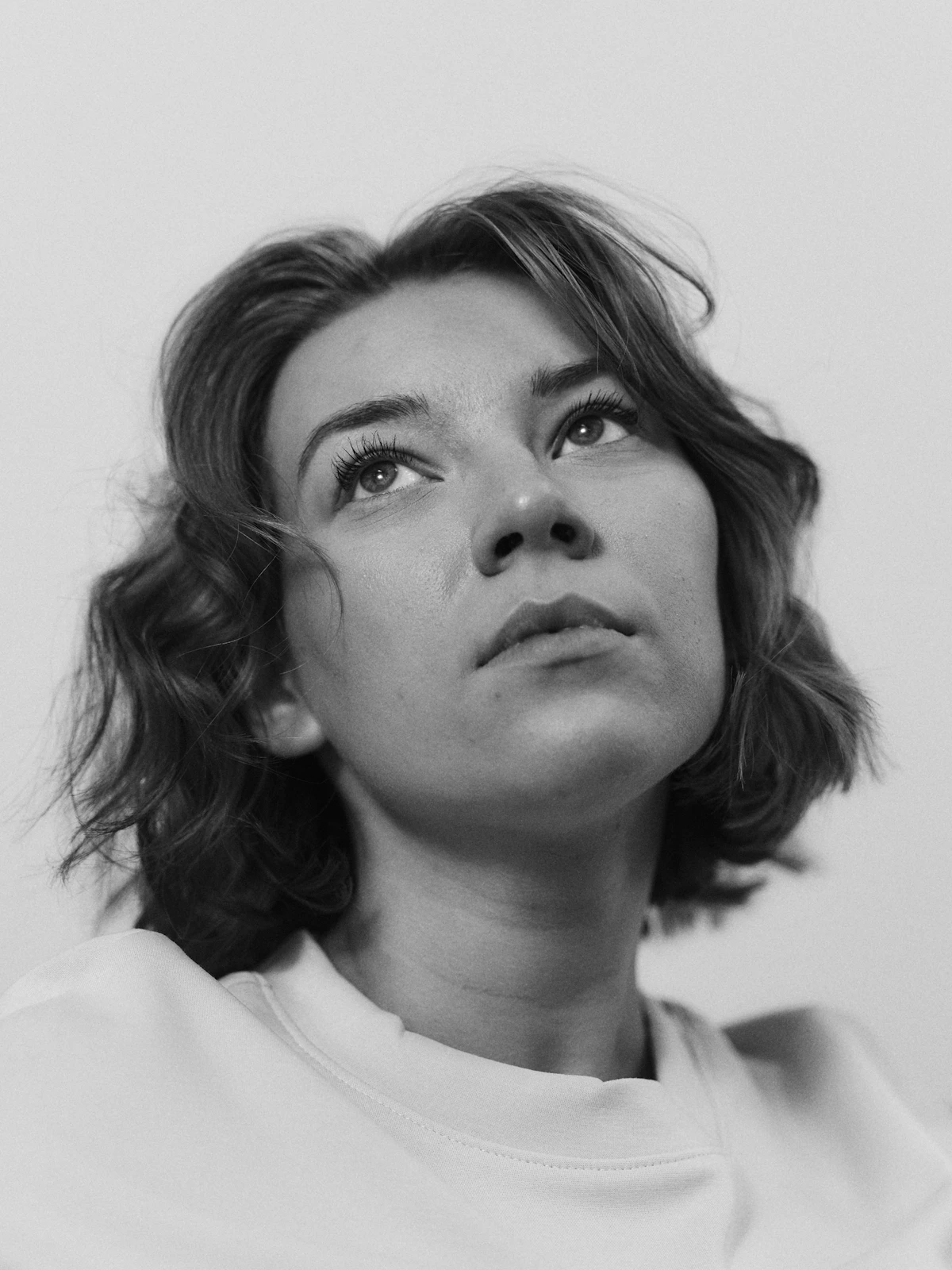 Calm black-and-white portrait of an adult woman looking up thoughtfully