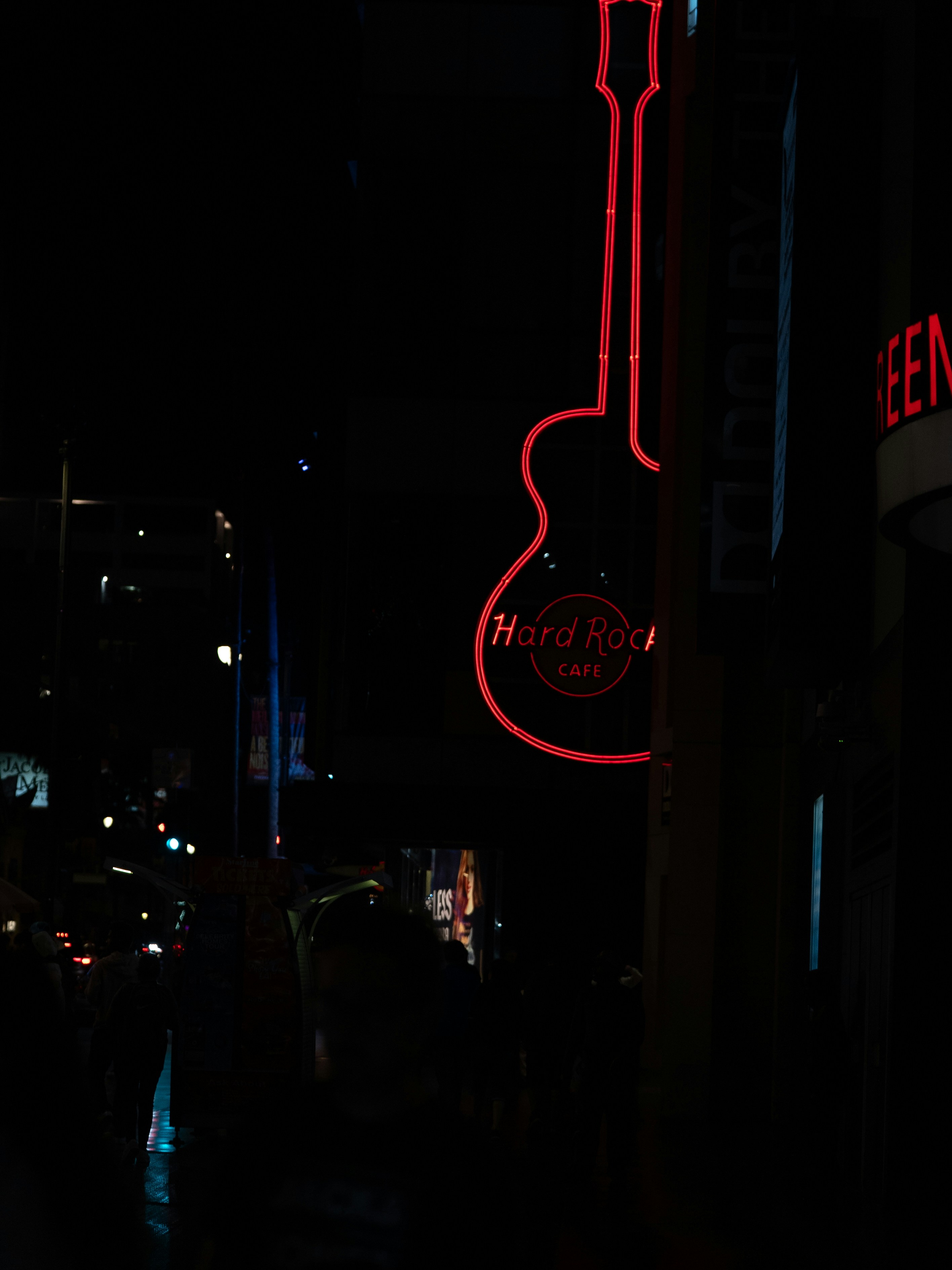 The neon hard rock cafe sign glows in the night.