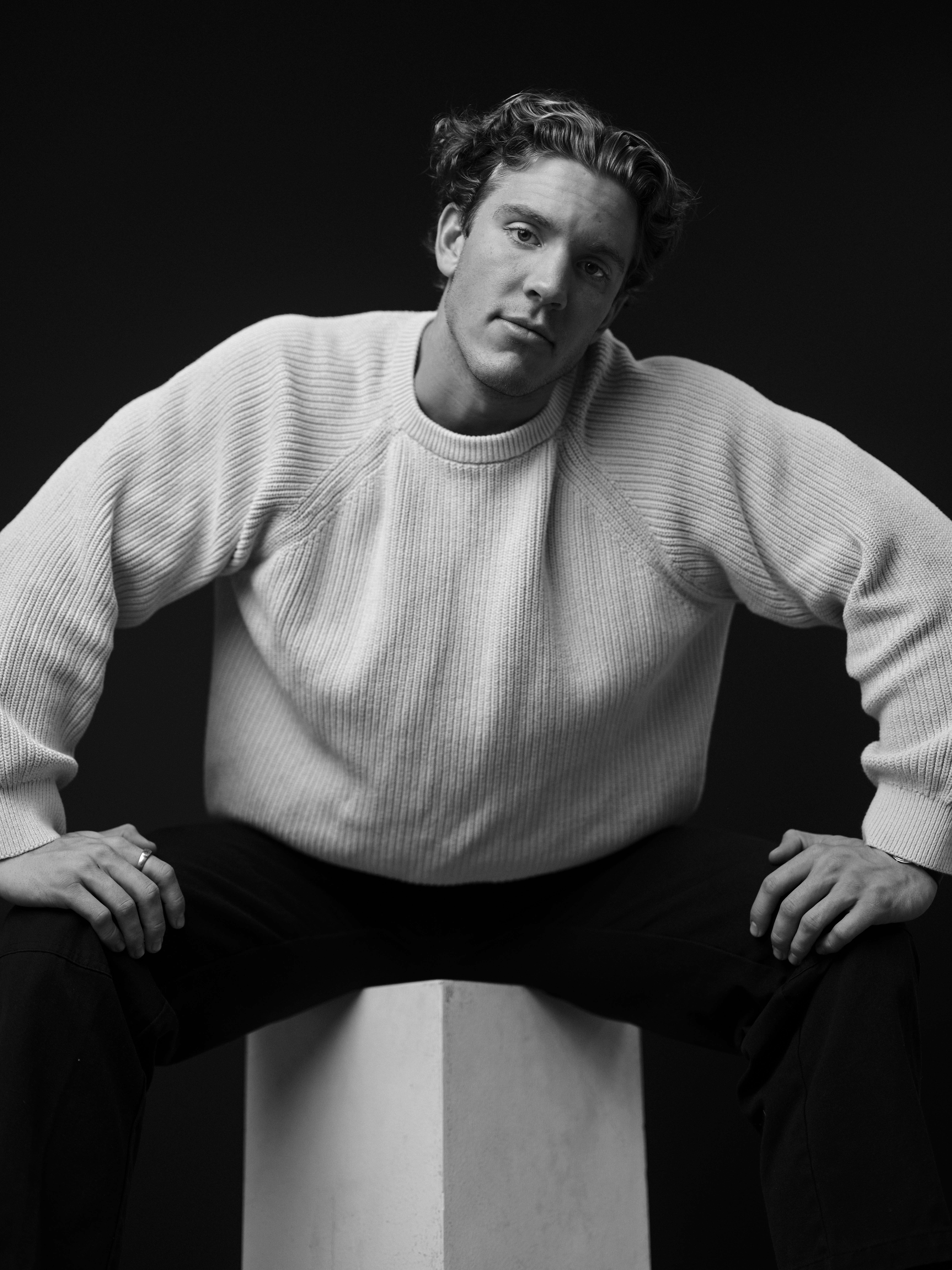 A man poses confidently in black and white.