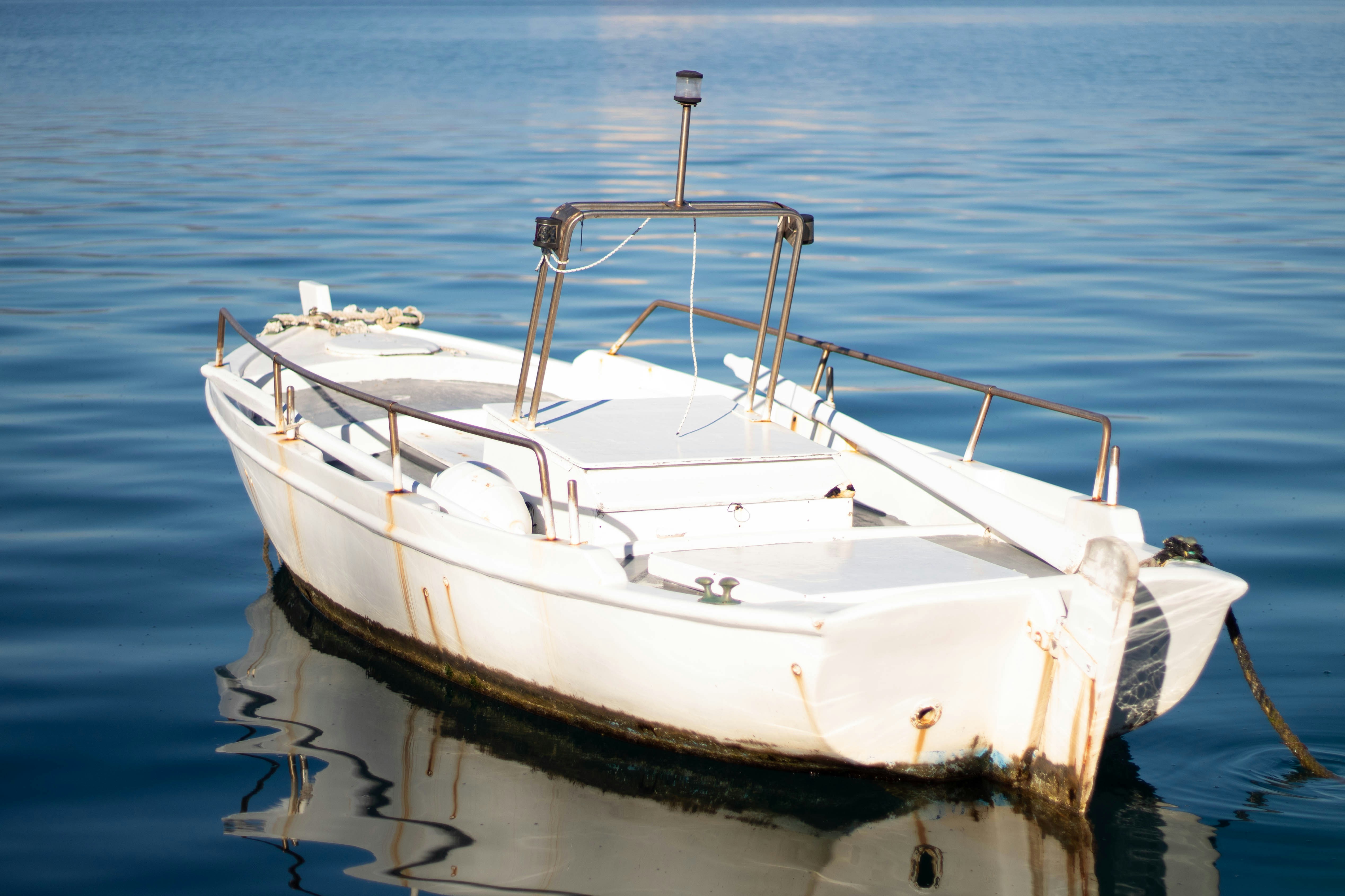 A white boat floats in blue water.